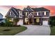 Stunning two-story home with a stone-accented entrance and well-manicured lawn at sunset at 3215 Bellamy Ridge Dr, Apex, NC 27523