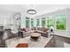 Spacious living room with large windows, hardwood floors, plush seating, and elegant lighting at 3215 Bellamy Ridge Dr, Apex, NC 27523
