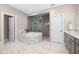 Luxurious main bathroom featuring a soaking tub, glass shower, tile floors, and modern finishes at 3215 Bellamy Ridge Dr, Apex, NC 27523