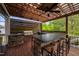Outdoor kitchen with stone accents, built-in grill, overhead pergola and bar seating at 3215 Bellamy Ridge Dr, Apex, NC 27523