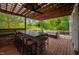 Outdoor living space featuring a stone bar, comfortable seating, and a serene view at 3215 Bellamy Ridge Dr, Apex, NC 27523