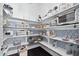 Well-stocked pantry with patterned wallpaper, white shelves, and organized storage containers at 3215 Bellamy Ridge Dr, Apex, NC 27523