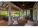 Inviting covered patio featuring an outdoor bar, dining area, and comfortable seating with views of nature at 3215 Bellamy Ridge Dr, Apex, NC 27523