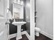Modern powder room featuring a pedestal sink, stylish mirror, and dark walls at 3215 Bellamy Ridge Dr, Apex, NC 27523