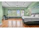 Bright bedroom features hardwood floors, large windows, a ceiling fan, and contemporary decor at 323 W Main St # C, Durham, NC 27701