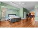 Large bedroom features hardwood floors, an accent wall, and a view to other living space at 323 W Main St # C, Durham, NC 27701