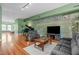 Spacious living room featuring a piano, hardwood floors, and unique accent wall at 323 W Main St # C, Durham, NC 27701