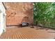 Large outdoor patio features wooden deck, brick wall, bench and outdoor lounge chair at 323 W Main St # C, Durham, NC 27701