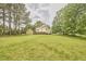 Expansive backyard view showing the house and shed, framed by lush greenery and mature trees at 3809 Victorian Grace Ln, Apex, NC 27539