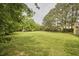 Spacious, open backyard with mature trees, offering ample space and privacy at 3809 Victorian Grace Ln, Apex, NC 27539