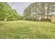 Open backyard with mature trees providing shade, offering a serene and private setting at 3809 Victorian Grace Ln, Apex, NC 27539