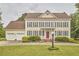 Traditional two-story home with yellow siding, a red door, a well-manicured lawn, and a two-car garage at 3809 Victorian Grace Ln, Apex, NC 27539