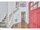 Bright foyer with hardwood floors, staircase, and red front door at 3809 Victorian Grace Ln, Apex, NC 27539