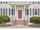 Charming front porch with brick steps, decorative plants, and a vibrant red door at 3809 Victorian Grace Ln, Apex, NC 27539