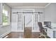 Office with hardwood floors, wainscoting, sliding barn doors, and a desk at 3809 Victorian Grace Ln, Apex, NC 27539