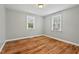 Inviting bedroom with hardwood floors, natural light, and a view of the yard at 3902 Booker Ave, Durham, NC 27713