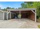 Large carport featuring a seating area, gray paint, and a wooden shed in the background at 3902 Booker Ave, Durham, NC 27713