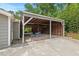 Large carport featuring a seating area, gray paint, and a lush green background at 3902 Booker Ave, Durham, NC 27713