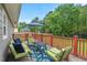 Relax on the home's deck with its green chairs, blue rug, and outdoor furniture at 3902 Booker Ave, Durham, NC 27713