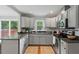 Modern kitchen with stainless steel appliances, gray cabinets, tile backsplash, and granite countertops at 3902 Booker Ave, Durham, NC 27713