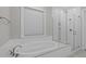 Bright bathroom featuring a soaking tub beneath a window and a glass-enclosed shower at 400 Chickasaw Plum Dr, Holly Springs, NC 27540