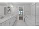 Well-lit bathroom with double sinks, white cabinets, soaking tub, and connecting bedroom at 400 Chickasaw Plum Dr, Holly Springs, NC 27540
