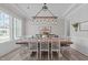 Dining room featuring a large table, wainscoting, designer lighting, and neutral paint at 400 Chickasaw Plum Dr, Holly Springs, NC 27540