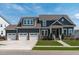 Beautiful two-story home featuring a three car garage and manicured lawn at 400 Chickasaw Plum Dr, Holly Springs, NC 27540