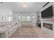 Living room featuring a fireplace, sofa, windows, and a decorative rug at 400 Chickasaw Plum Dr, Holly Springs, NC 27540