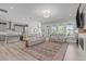 Bright living room featuring a rug, sofa, fireplace, and adjacent kitchen at 400 Chickasaw Plum Dr, Holly Springs, NC 27540