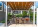 This outdoor kitchen features a pizza oven, BBQ grill, bar seating, and a wood plank roof at 400 Chickasaw Plum Dr, Holly Springs, NC 27540