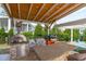 Outdoor kitchen under pergola features pizza oven, sink, barbeque, and bar seating at 400 Chickasaw Plum Dr, Holly Springs, NC 27540