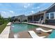 This spacious backyard features a sparkling pool with waterfalls, a hot tub, and an inviting outdoor seating area at 400 Chickasaw Plum Dr, Holly Springs, NC 27540