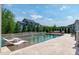 Relax in this backyard oasis, featuring a pool with a tanning ledge, waterfalls, and comfortable outdoor furniture at 400 Chickasaw Plum Dr, Holly Springs, NC 27540