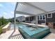 This backyard features a sparkling pool, hot tub, patio area, and lush landscaping for luxurious outdoor living at 400 Chickasaw Plum Dr, Holly Springs, NC 27540