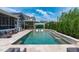 Inviting backyard pool featuring a sun-shelf, water feature, and outdoor seating area at 400 Chickasaw Plum Dr, Holly Springs, NC 27540