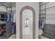 Spacious walk-in closet with wood floors, custom shelving, and an arched doorway to the bathroom at 400 Chickasaw Plum Dr, Holly Springs, NC 27540