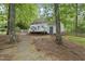 Home's back exterior featuring a deck, surrounded by trees, and an access door at 404 Trappers Run Dr, Cary, NC 27513