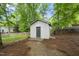 A backyard shed with light siding and a gray door provides backyard storage space and organization at 404 Trappers Run Dr, Cary, NC 27513