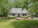 Charming home featuring a covered front porch, dormer windows, and a well-manicured lawn with lush landscaping at 404 Trappers Run Dr, Cary, NC 27513