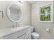 Bathroom featuring a vanity with quartz countertop, a round mirror, and a toilet at 4041 Brook Cross Dr, Apex, NC 27539