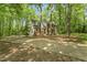 Long concrete driveway leading to a brick home surrounded by lush trees and greenery at 4041 Brook Cross Dr, Apex, NC 27539