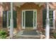 Welcoming front entrance with green door, brick details, and white columns under covered porch at 4041 Brook Cross Dr, Apex, NC 27539