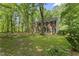 Two-story brick home with black shutters set back on a lush green lawn among mature trees at 4041 Brook Cross Dr, Apex, NC 27539