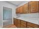 Kitchen with wooden cabinets and white countertop with a view into a carpeted living space at 4041 Brook Cross Dr, Apex, NC 27539
