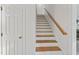 Bright staircase featuring hardwood treads, white risers, and a wooden handrail at 4041 Brook Cross Dr, Apex, NC 27539