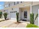 Inviting front entrance with a black framed glass door, one-car garage, and manicured landscaping at 412 Stone Flower Ln, Raleigh, NC 27603