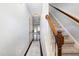 A long hallway with hardwood floors leads to a carpeted staircase at 412 Stone Flower Ln, Raleigh, NC 27603