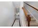 Bright hallway with staircase, light gray walls, dark wood floors, and a patterned rug at 412 Stone Flower Ln, Raleigh, NC 27603