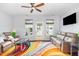 A bright living room with a colorful rug, ceiling fan and natural light at 412 Stone Flower Ln, Raleigh, NC 27603